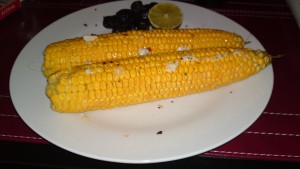 Corn-on-the-cob with lime and black olives